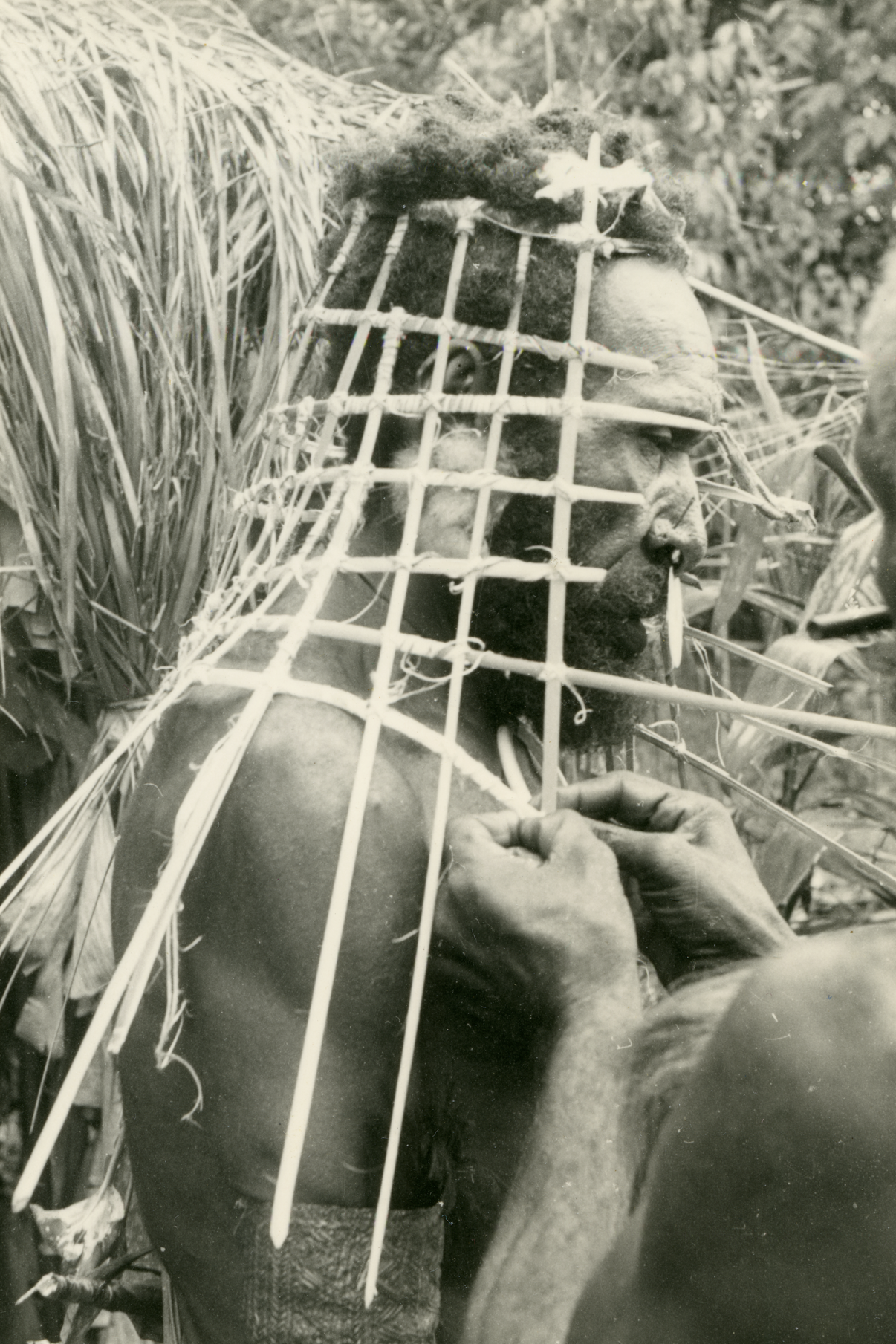 Man being fitted for ceremonial headdress
