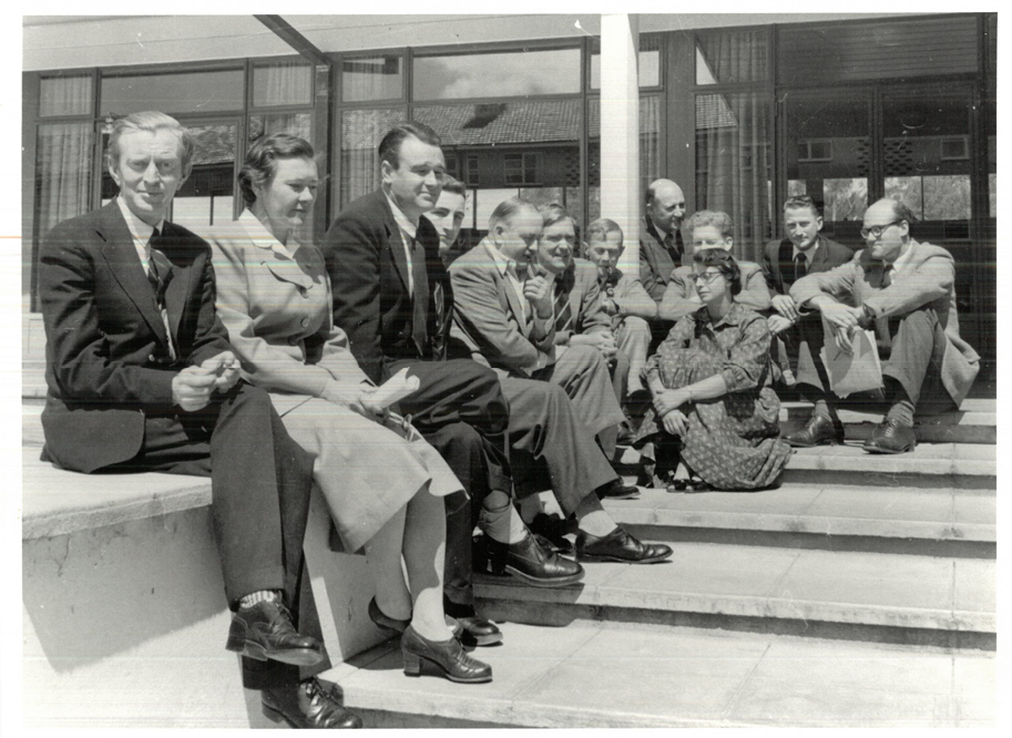 Black and white photograph of group of people sitting outside
