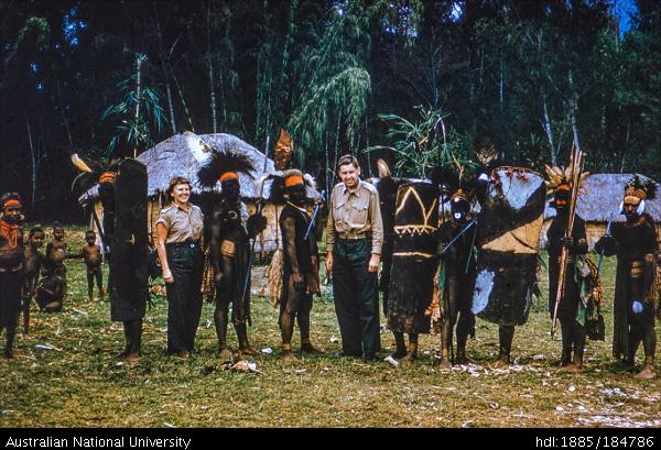 European man and woman with Papua New Guineans in ceremonial dress