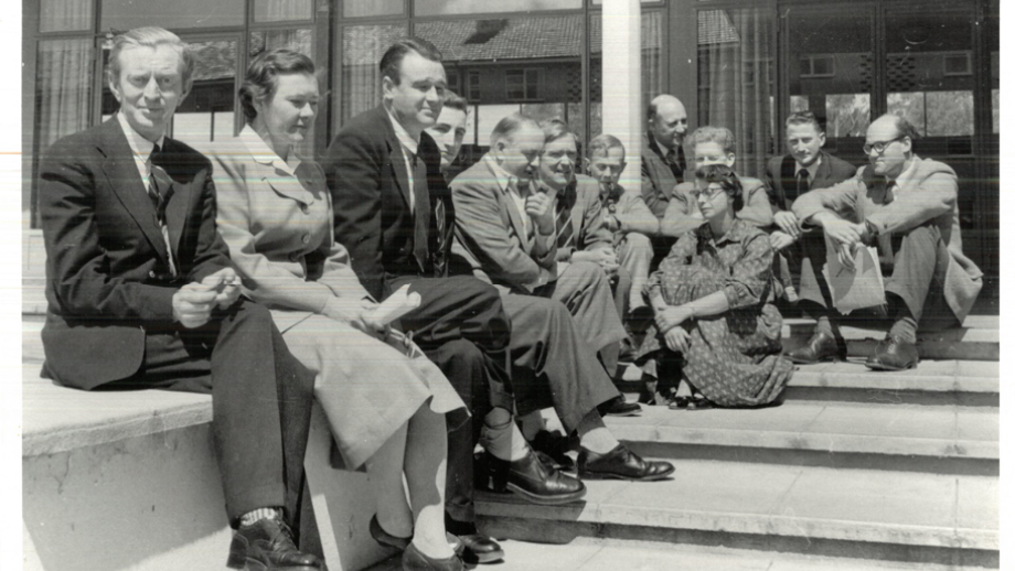 Black and white photograph of group of people sitting outside