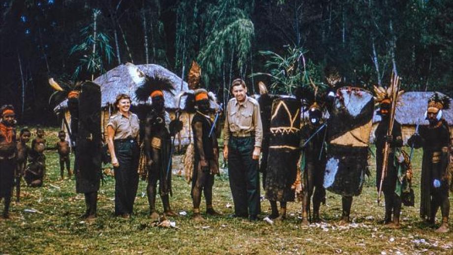 European man and woman with Papua New Guineans in ceremonial dress