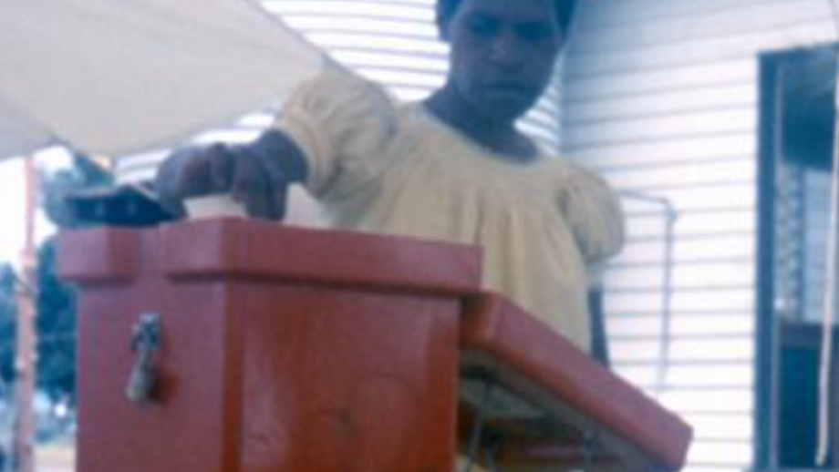 Woman placing ballot in red ballot box