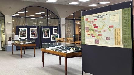 Photo showing exhibition display cases and a map