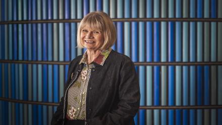 Grace Karskens standing in front of a blue background